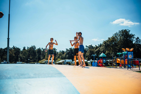 Bambini che giocano su un cuscino saltellante al parco vacanze Eurocamping Vessem BV in Brabante Settentrionale, Paesi Bassi.