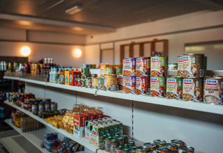 Supermarkt in Eurocamping Vessem BV in Noord-Brabant met rekken vol ingeblikt voedsel en producten.