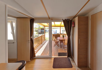 Udsigt fra SunLodge Aspen Combi på Camping Leï Suves i Frankrig med terrasse og spisebord udenfor.