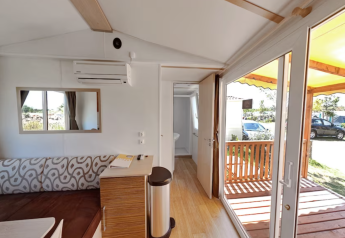 Intérieur lumineux de la SunLodge Aspen Combi avec vue sur terrasse au Camping Leï Suves, France.