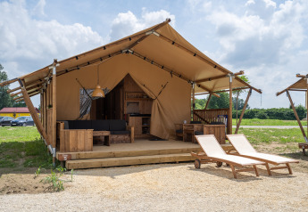 SunLodge Taiga: Amplia tienda glamping con terraza de madera, muebles y dos tumbonas exteriores.