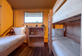 Cozy SunLodge Taiga room at Camping Cisano/San Vito, Italy, featuring wooden bunk beds and natural light.