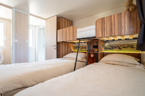 Chambre familiale à SunLodge Catalpa, Camping Cisano/San Vito, Italie, avec lits superposés et lits simples.