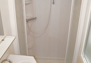Baño moderno con ducha, lavabo y espejo en SunLodge Aspen Premium en Camping Cisano/San Vito en Italia.