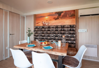 Comedor en SunLodge BigLeaf del Camping Cisano/San Vito en Italia, con decoración moderna y motivos naturales.