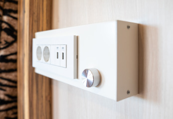 Primo piano di un pannello moderno con prese e porte USB e manopola al SunLodge BigLeaf in Italia.