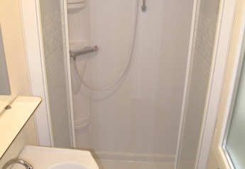 Compact bathroom with shower cabin and sink in SunLodge Redwood at Camping Cisano/San Vito, Italy.