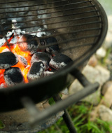 Glowing charcoal briquettes in a grill, ready for outdoor cooking at Camping 'de Val' in Zeeland.