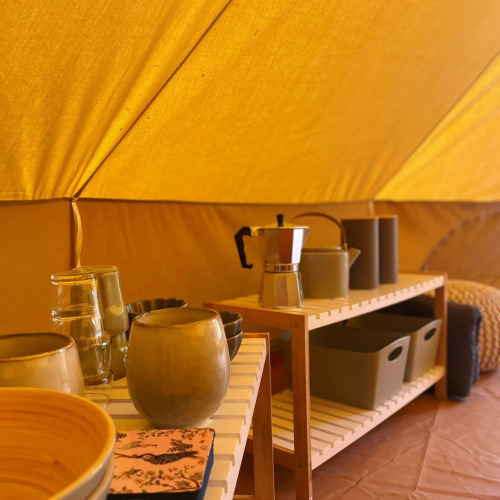 Innenaufnahme eines Safarizeltes bei Belltent, Camping Drei Spatzen, mit Geschirr und Küchenutensilien.