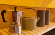 Coffee pot and teapot on a wooden shelf inside a Belltent safari tent at Camping Drei Spatzen, Germany.