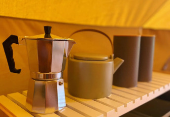 Caffettiera e teiera su una mensola di legno in una tenda safari Belltent a Camping Drei Spatzen, Germania.