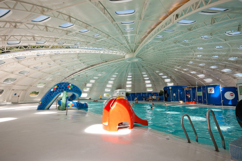 Piscina coperta con scivoli e tetto a cupola presso il villaggio hu Birkelt Village a Mersch, Lussemburgo.
