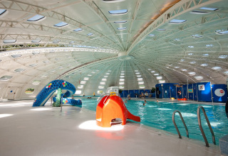 Piscine intérieure avec toboggans et toit en dôme au village vacances hu Birkelt à Mersch, Luxembourg.