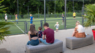 Familias disfrutan viendo a los niños jugar fútbol en hu Birkelt Village, un parque vacacional en Mersch, Luxemburgo.