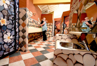 Un colorido baño en hu Birkelt Village, Mersch, Luxemburgo, con decoraciones de piedras y flores.