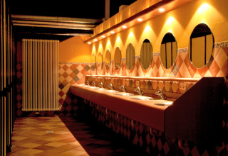 Modern restroom facilities with multiple sinks and round mirrors at hu Birkelt Village in Mersch, Luxembourg.