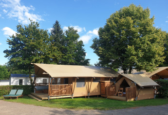 Tiendas safari SunLodge Taiga & Kambi en hu Birkelt Village, Luxemburgo, rodeadas de árboles verdes.