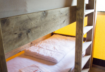 Una litera de madera en una tienda safari en Glamping de Vakantiepark Klein Strand, Bélgica.