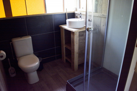 Badkamer in safaritent Glamping bij Vakantiepark Klein Strand met toilet, douche en wastafel.