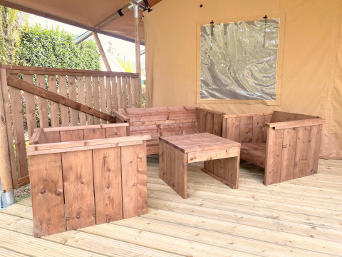 Wooden furniture set inside a safari tent at Glamping, Vakantiepark Klein Strand in Belgium.