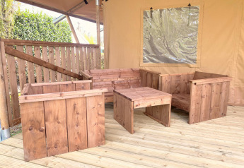 Conjunto de muebles de madera en una tienda de safari en Glamping del Vakantiepark Klein Strand, Bélgica.