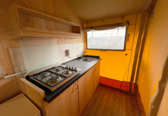 Coin cuisine dans une tente safari au Glamping de Vakantiepark Klein Strand en Belgique, avec gazinière et évier.
