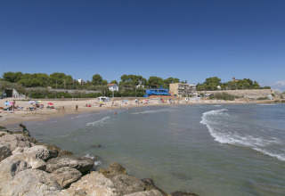 Spiaggia presso Camping Vilanova Park in Catalogna, Spagna, con persone che si godono mare e sole.