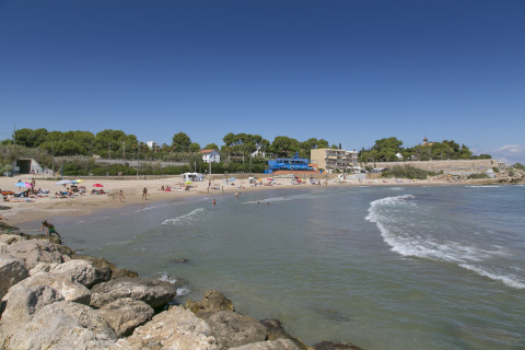 Strandzicht aan Camping Vilanova Park in Catalonië, Spanje, met bezoekers die genieten van zon en zee.