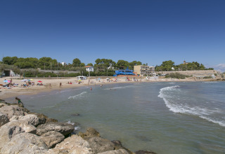 Strand en zee bij Camping Vilanova Park in Catalonië, Spanje, met mensen die genieten van zon en water.