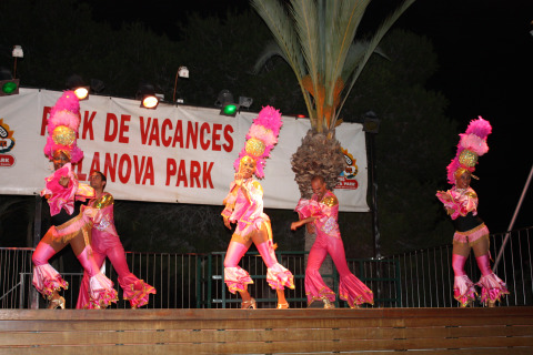 Dansers in kleurrijke roze kostuums treden op het podium op bij Camping Vilanova Park in Catalonië, Spanje.