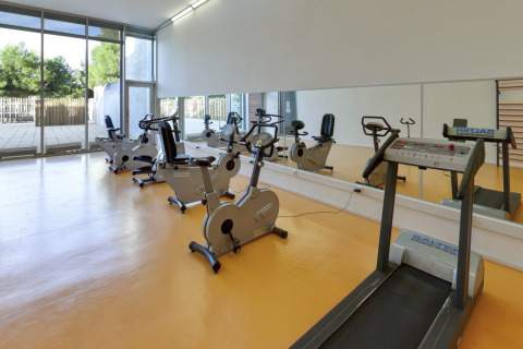Sala fitness con tapis roulant e cyclette al Camping Vilanova Park, villaggio in Catalogna, Spagna.