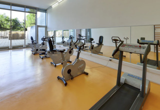 Sala fitness con tapis roulant e cyclette al Camping Vilanova Park, villaggio in Catalogna, Spagna.
