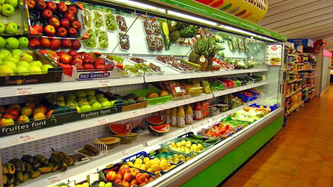 Reparto frutta e verdura in un supermercato al Camping Vilanova Park in Catalogna, Spagna, con prodotti freschi.