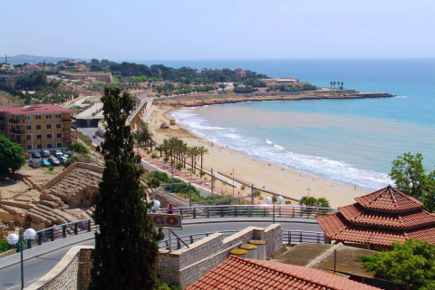 Veduta costiera vicino a Vilanova i la Geltrú, Catalogna, Spagna, con spiaggia sabbiosa, mare ed edifici.