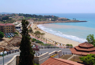 Veduta costiera vicino a Vilanova i la Geltrú, Catalogna, Spagna, con spiaggia sabbiosa, mare ed edifici.
