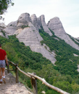 Persona caminando por un sendero rodeado de montañas rocosas y vegetación cerca de Vilanova i la Geltrú.