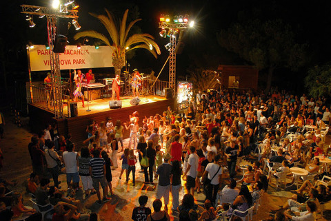 Espectáculo nocturno con música en vivo y público animado en Camping Vilanova Park, Cataluña, España.