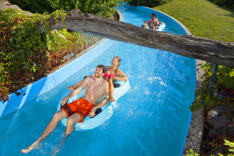 People relaxing on inflatable rings in a lazy river at Camping Terme Catez holiday park in Slovenia.