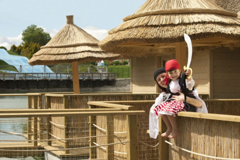 Mère et enfant déguisés en pirates sur une terrasse au toit de chaume au Camping Terme Catez en Slovénie.