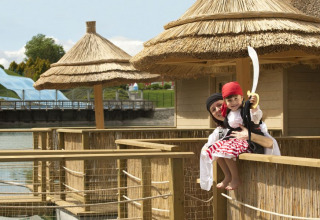 Madre e figlio vestiti da pirati su una terrazza con tetto in paglia al Camping Terme Catez, Slovenia.