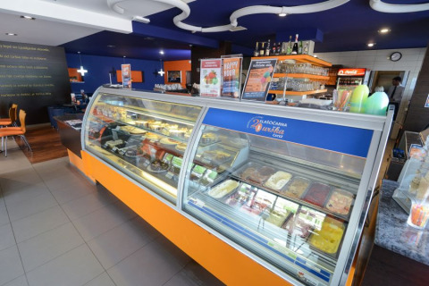 Heladería y cafetería con decoración colorida y vitrinas de postres en Camping Terme Catez, Baja Sava, Eslovenia.