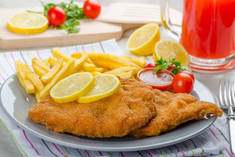 Assiette de schnitzel, frites, citron et tomates cerises au Camping Terme Catez, Slovénie.