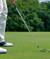 Un golfista con pantalones blancos y zapatos negros se prepara para golpear la bola cerca de Brežice, Eslovenia.