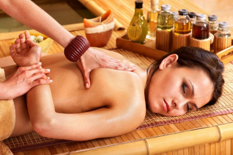 Donna che riceve un massaggio rilassante alla schiena con oli essenziali al Camping Terme Catez, Slovenia.