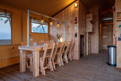 Interno della tenda safari SunLodge Pamoja & Kambi con mobili in legno al Camping Terme Catez, Slovenia.