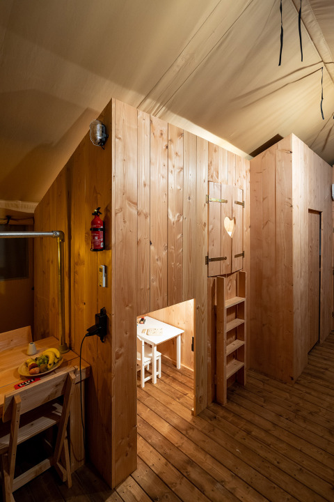 Interieur van safari tent SunLodge Pamoja&Kambi op Camping Terme Catez, Slovenië, met houten meubels.