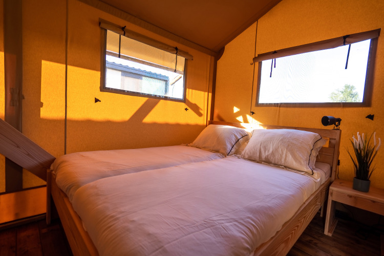Chambre d'une tente safari SunLodge Pamoja&Kambi au Camping Terme Catez en Slovénie, éclairée au soleil.