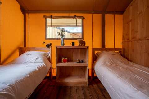 Interior de una tienda safari SunLodge Pamoja&Kambi en Camping Terme Catez, Eslovenia, con dos camas individuales.