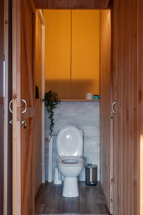 Toilet met houten bekleding in een SunLodge Pamoja & Kambi safaritent op Camping Terme Catez, Slovenië.