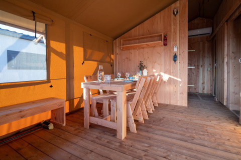 Binnenkant van de SunLodge Taiga safaritent op Camping Terme Catez in Slovenië met houten eettafel.